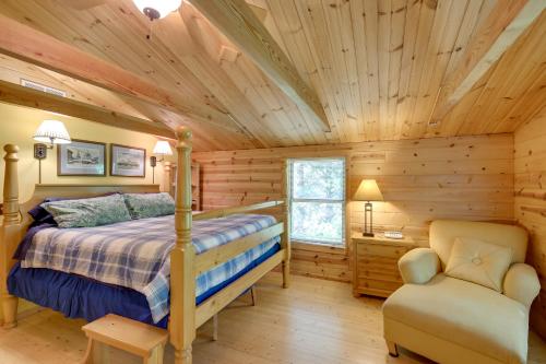 a log cabin bedroom with a bed and a chair at Lakefront Hazelhurst Cabin Dock and Pool Table in Hazelhurst