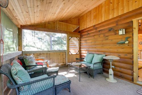 a screened in porch with chairs and a table at Lakefront Hazelhurst Cabin Dock and Pool Table in Hazelhurst