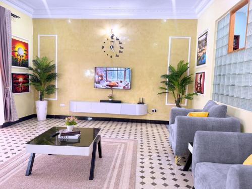 ein Wohnzimmer mit Sofa und Tisch in der Unterkunft Luxurious 3 bedroom bungalow in Kampala in Namugongo