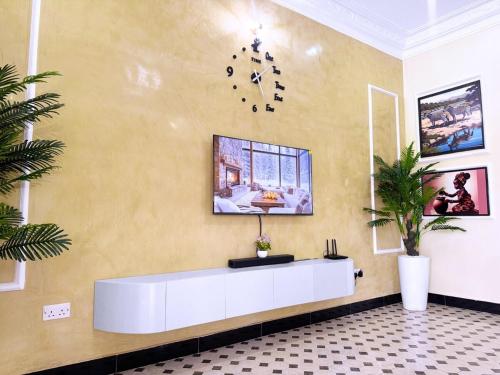 a lobby with a reception desk and a clock on the wall at Luxurious 3 bedroom bungalow in Kampala in Namugongo