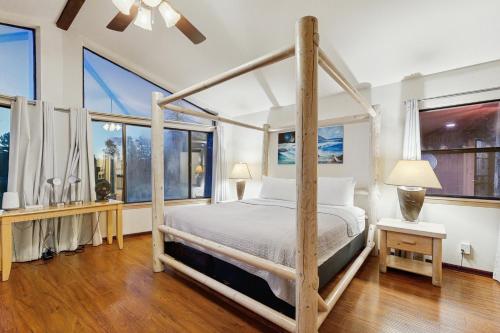 Schlafzimmer mit Himmelbett und großen Fenstern in der Unterkunft Lynx Cabin in Elden Pueblo