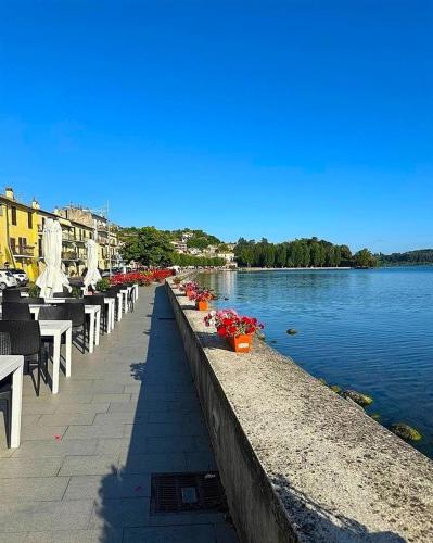 a row of tables and chairs next to a body of water at Civico 95 Alloggio Turistico in Marta
