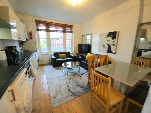 a kitchen and living room with a table and chairs at King's Cross & Angel Area, 4 Bedrooms Home with 7 beds & Private Rooftop - Walk to St Pancras International in London
