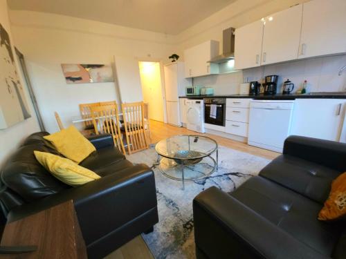 a living room with a couch and a table and a kitchen at King's Cross & Angel Area, 4 Bedrooms Home with 7 beds & Private Rooftop - Walk to St Pancras International in London