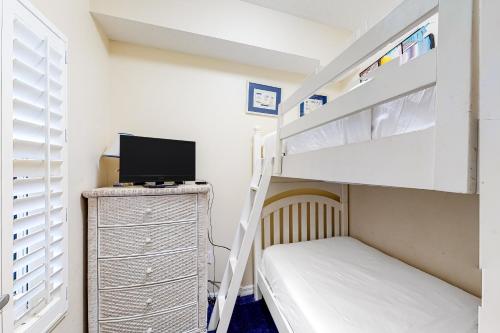 a bedroom with a bunk bed and a desk with a television at Summerwind 0402 in Navarre