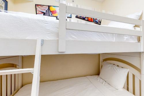 a bunk bed in a small room with a bed in a bunk room at Summerwind 0402 in Navarre