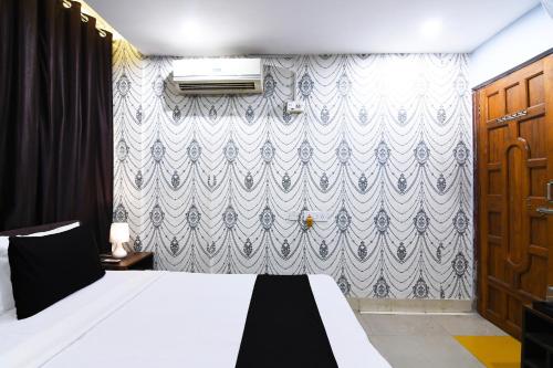 a bedroom with a bed and a blue and white wallpaper at Hotel O The Red Rose Near Kalikapur in Jādabpur