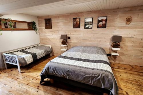 1 Schlafzimmer mit 2 Betten in einem Zimmer mit Holzwänden in der Unterkunft Maison au pied des montagnes ariégeoises in Quié