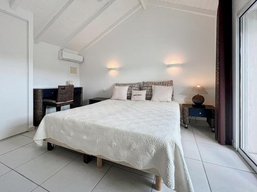 Saint MartinにあるMango Rouge, 2 bedrooms & poolの白いベッドルーム(大型ベッド1台、デスク付)