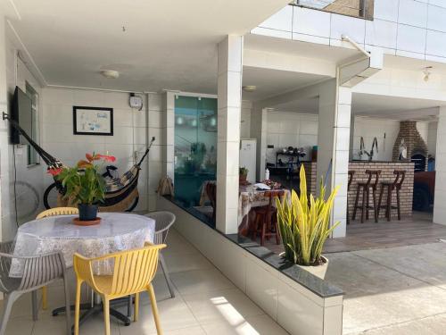 a dining room and living room with a table and chairs at Cantinho da Barra in Barra dos Coqueiros
