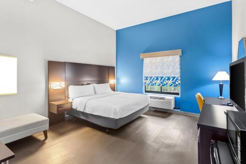 a hotel room with a bed and a blue wall at Holiday Inn Express & Suites Cross Lanes by IHG in Cross Lanes