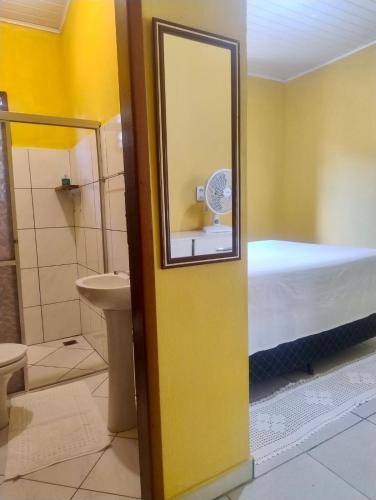a bathroom with a mirror and a bed in a room at Pousada Pássaros da Manhã in Vale do Capao