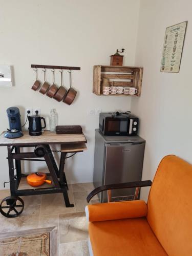 a kitchen with a table with a microwave and a table with a microwave at La Chalan d'hier in Nort-sur-Erdre