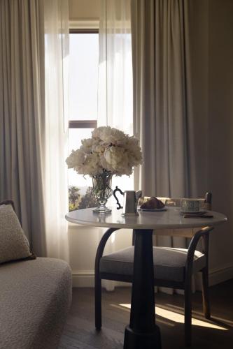 a vase of flowers on a table in front of a window at The Langham Huntington, Pasadena in Pasadena