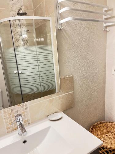 a bathroom with a white sink and a mirror at La Falaisienne - Appartement pour 4 au cœur de Falaise - "Larès" in Falaise