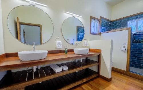 une salle de bain avec deux lavabos et deux miroirs dans l'établissement Infinite Sea - 3 bed 2 bath Upper Unit Caye Caulker, à Caye Caulker