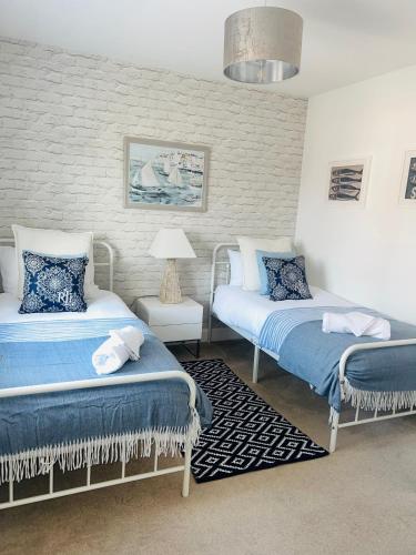 a bedroom with two beds with blue and white at Southkey House in Repton