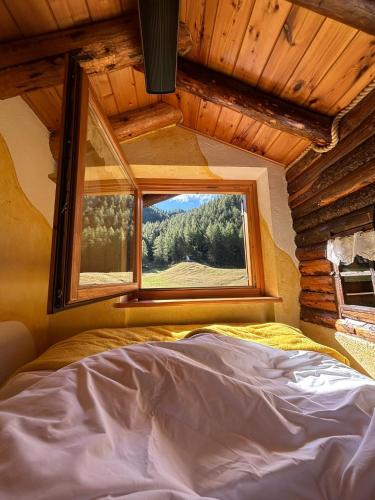 a bed in a room with a window at Le Pailler in Valtournenche