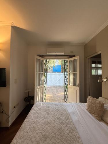 une chambre avec un lit et une porte donnant sur une cour dans l'établissement La Petite Maison San Isidro, à San Isidro