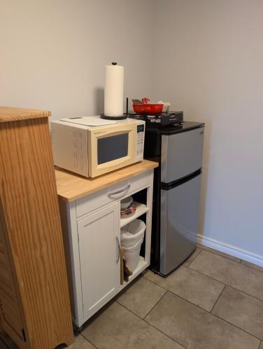 a microwave sitting on top of a counter next to a refrigerator at Gordie's Inn & Suites in Alert Bay