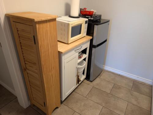 a microwave sitting on top of a counter next to a refrigerator at Gordie's Inn & Suites in Alert Bay