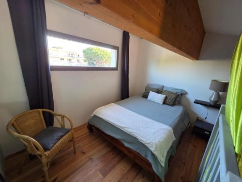 Un dormitorio pequeño con una cama y una ventana. en Blue Beach La Ciotat, en La Ciotat