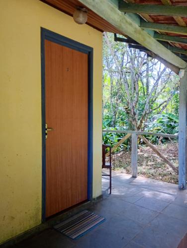 a wooden door in a room with a tree at Pousada Arboretum in Penedo