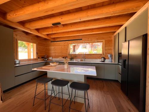 a kitchen with a large island with bar stools at Chalet les 3 Montagnards - 200m des pistes in Montgenèvre