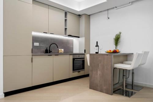 - une cuisine avec des placards blancs et un comptoir avec un évier dans l'établissement Sia North Green, à Voluntari