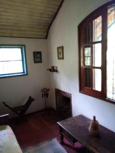 a living room with a table and a fireplace at Pousada Arboretum in Penedo