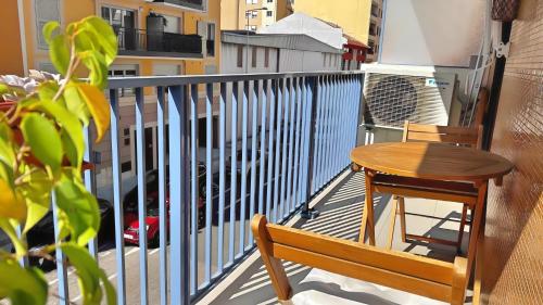 a wooden chair and a table on a balcony at Appartement confortable avec balcon - Proche Gare Riquier SNCF in Nice