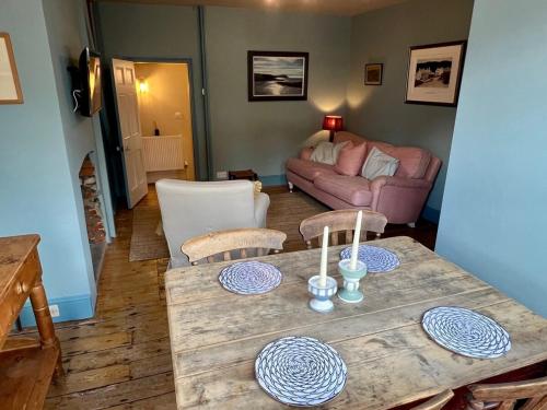 a living room with a table and a couch at Pilots House Aldeburgh in Aldeburgh