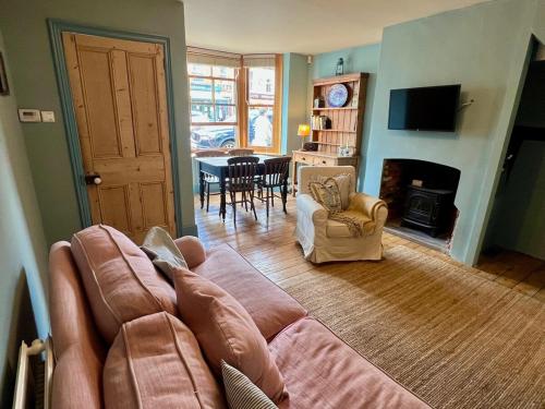 a living room with a couch and a fireplace at Pilots House Aldeburgh in Aldeburgh