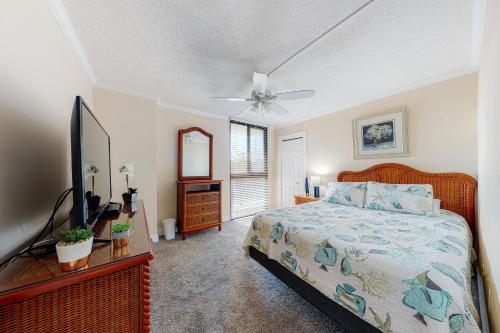 Un dormitorio con una cama y un ventilador de techo. en Sea Colony - 110 Chesapeake House Rd, en Sea Colony