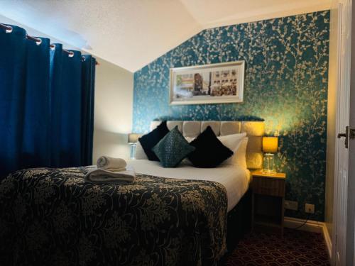 a bedroom with a bed and a blue wall at 4 Sisters Inn in North Kyme
