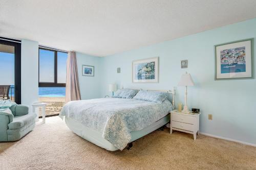 a blue bedroom with a bed and a chair at Sea Colony - 505 Chesapeake House Rd in Sea Colony