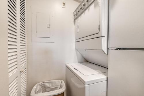 a small kitchen with a refrigerator and a trash can at Sea Colony - 107 Chesapeake House Rd in Sea Colony