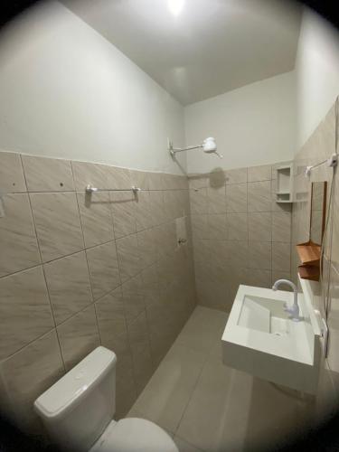 een badkamer met een wit toilet en een wastafel bij Dormitório Barreto in Bom Jesus da Lapa