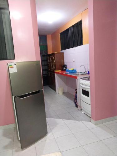 a small kitchen with a refrigerator and a stove at Piso de 2 camas in Moyobamba