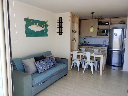 un soggiorno con un divano, un tavolo e una cucina di Arriendo departamento Concón 2H/2B a Concón