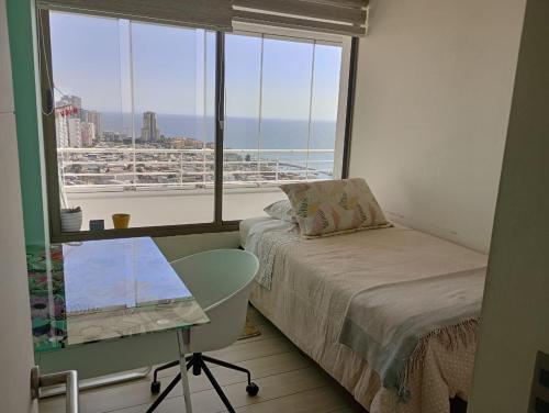 una camera da letto con un letto, una scrivania e una finestra di Arriendo departamento Concón 2H/2B a Concón