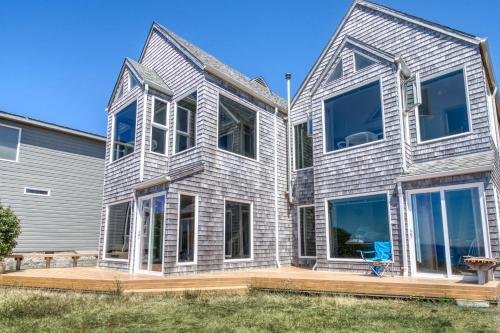 ein Haus mit großen Fenstern und einem blauen Stuhl in der Unterkunft Beach Loop Condo #2 - South Unit in Bandon