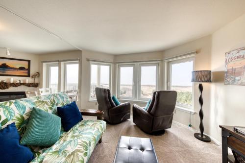 a living room with a couch and chairs and windows at Boardwalk Adventures in Long Beach