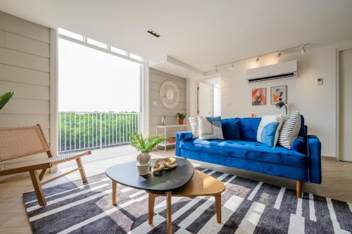 ein Wohnzimmer mit einem blauen Sofa und einem Tisch in der Unterkunft Casa La Costa By Wynwood House in Panama-Stadt