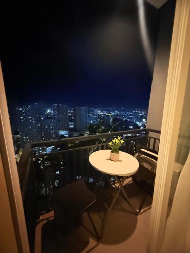 ein Tisch mit einer Topfpflanze auf einem Balkon in der Nacht in der Unterkunft Balcony Studio Ayala with Ultra-Fast 400 Mbps WiFi in Cebu City
