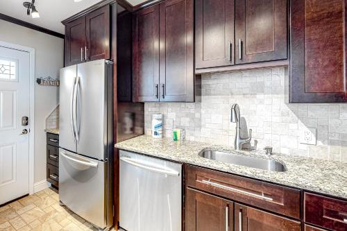 Una cocina con gabinetes de madera y un refrigerador de acero inoxidable. en Sea Palms 5D - Little Slice of Heaven, en Fort Walton Beach