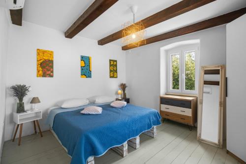 a bedroom with a blue bed and a window at Scuola Roveria in Juršići