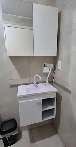 a bathroom with a white sink and a mirror at Apartamento praia Natal in Natal