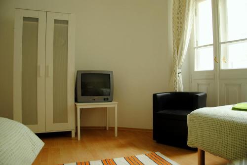 ワルシャワにあるセントラル ステーション ホステルのテレビ、椅子、ベッドが備わる客室です。