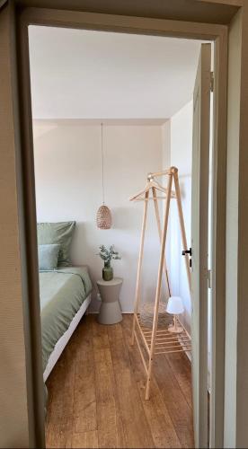 a bedroom with a bed and a wooden swing at La Terrasse de L Anse Maison avec Vue Mer et Spa Extérieur in Fermanville
